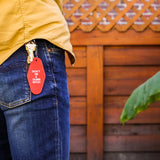 dont be a dumb bitch keychain in red at sew bonita in corpus christi shown on model with blue jeans